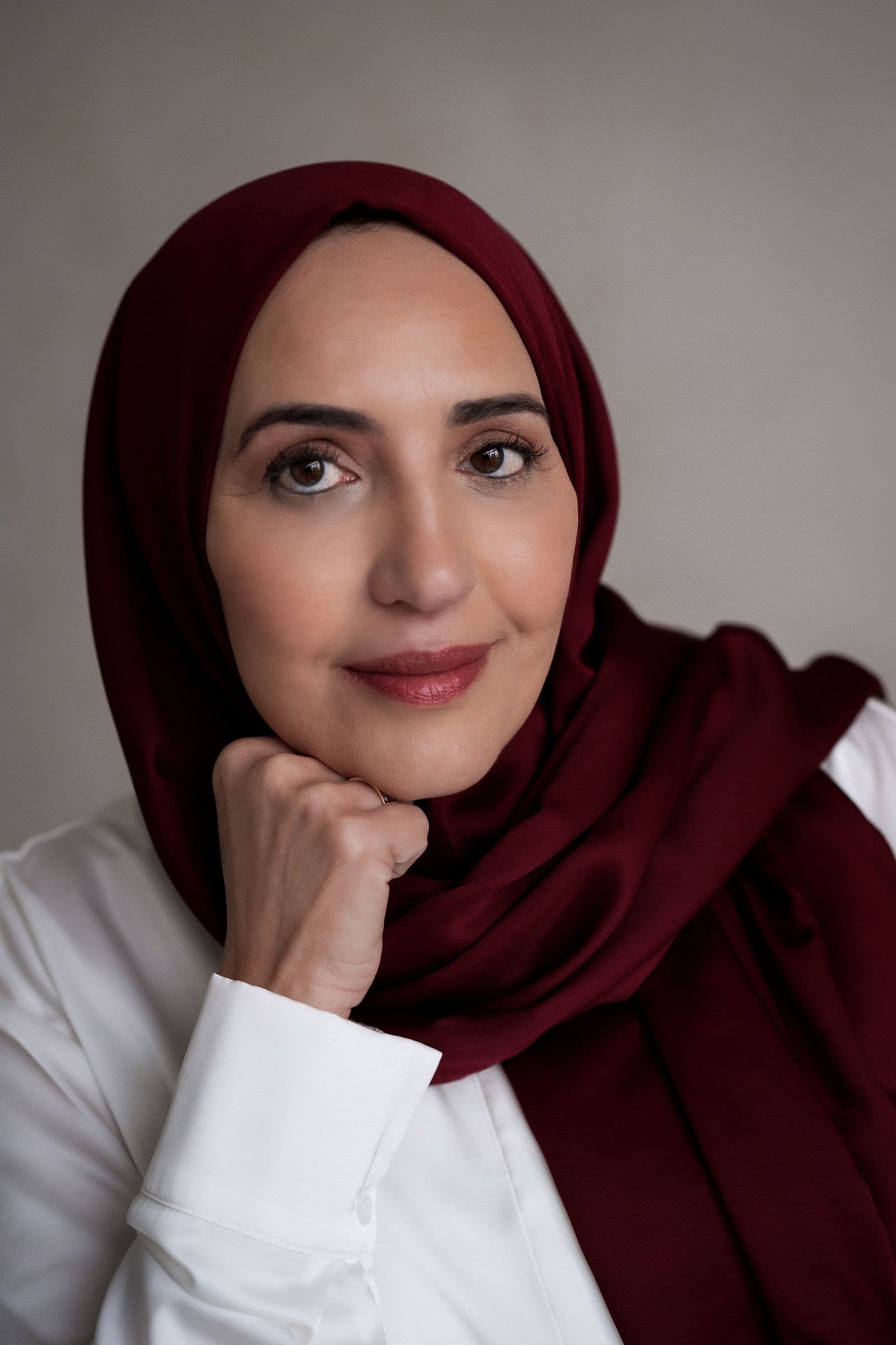 Portret van Najat Haddouch in een burgundy hoofddoek